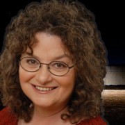 Smiling woman with glasses and curly dark hair